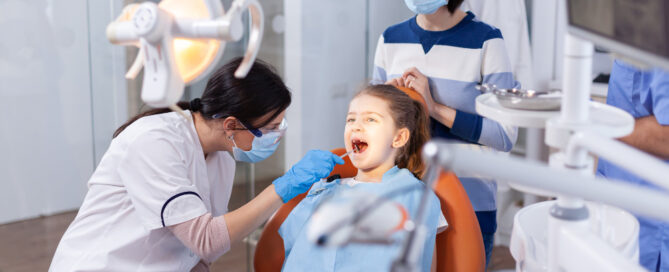 Simplifying Oral Health: The Benefits of Having a Family Dentist 2 angled mirror used by dentist doctor little girl with mouth open dental office dentistry specialist during child cavity consultation stomatology office using modern technology